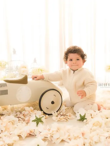 On the road to one year old! This playful shot with the toy car adds a fun element to the classic birthday photoshoot.