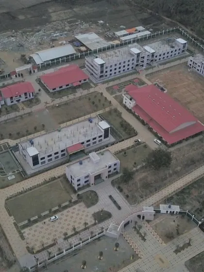 An actual aerial photograph of the UNACCO School campus, showing the realization of our masterplan, with buildings and sports facilities situated within the vast landscape.