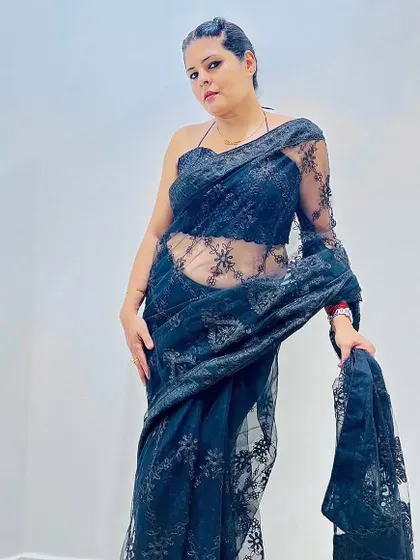 Another view of the black lace saree, showing its sheer texture and intricate floral pattern. It's a statement piece for any evening event.