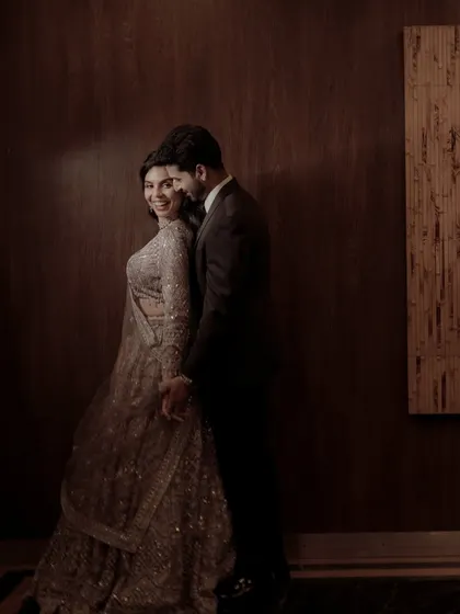 A happy, candid moment captured in a warm, moody light, showing the couple's genuine connection.