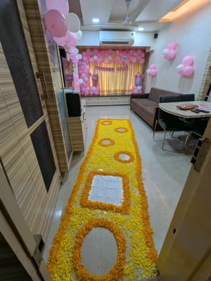 A clear overhead shot of the intricate flower petal runner designed for a welcome baby ceremony, showing the detailed patterns and colors.