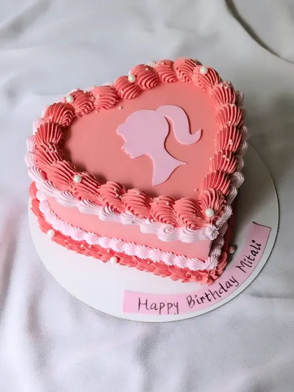 Life's better in pink! A vintage heart-shaped cake with a Barbie silhouette, perfect for a Barbie-themed birthday party.