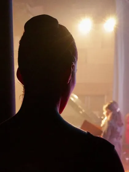 The quiet moment of anticipation in the wings before stepping into the spotlight. This is where focus and preparation meet the energy of the audience.