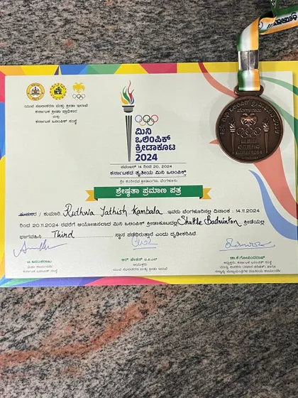 A close-up of the bronze medal and certificate from the Mini Olympics 2024. Every award represents countless hours of hard work.