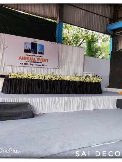 A clear view of the main stage for the Tara Chand annual function. The setup includes a formal dais for speakers, a podium, and simple, clean decorations suitable for a corporate awards ceremony.