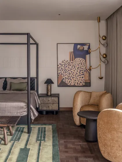 Another angle of the parent's bedroom, showing the cozy seating area. The plush, curved armchair adds a soft, sculptural element to the room, making it a perfect spot for reading.