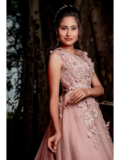 A beautiful portrait of the model in the light pink wedding gown, showcasing the delicate details and the matching hair accessory.