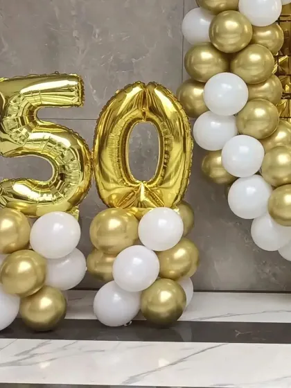 A close-up of the number '50' foil balloons on balloon pillars.