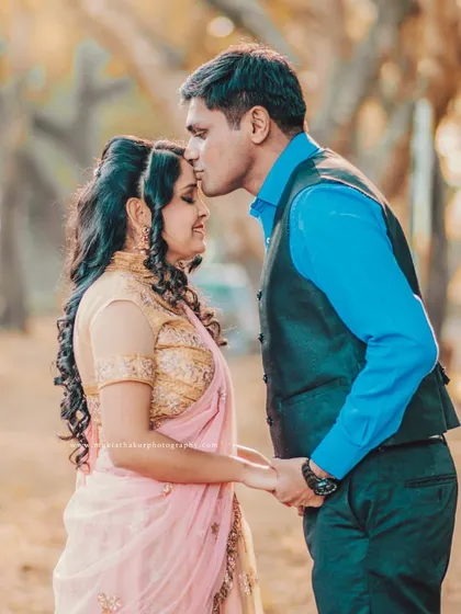 A tender forehead kiss, a classic expression of love and care. This was captured during a pre-wedding shoot with the couple in elegant, traditional-style outfits.