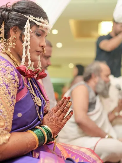 A side profile showing the intricate details of the bridal hairstyle and the placement of the Mundavalya (forehead jewelry).