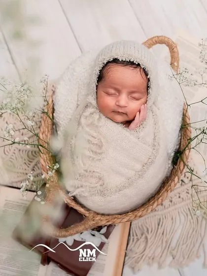 Another angle of this angelic newborn. We use soft, neutral tones and textures to keep the focus entirely on your baby's perfect little features.