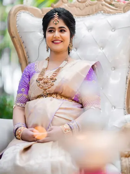 The picture of happiness and serenity. For her baby shower, we created a lovely look with a soft purple and gold theme, featuring an elegant updo and makeup that highlighted her joyful glow.