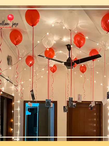 I love turning memories into part of the decor. This simple yet powerful setup uses helium balloons to float your favorite photographs from the ceiling, surrounded by the warm glow of fairy lights for a truly personal and romantic atmosphere.