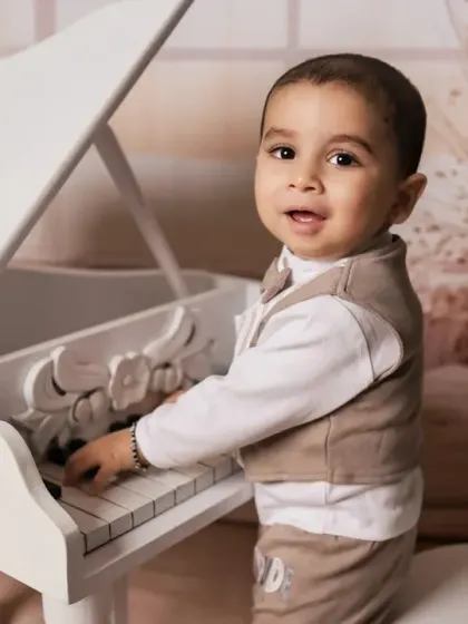 A close-up of our little pianist, capturing his happy expression as he plays.