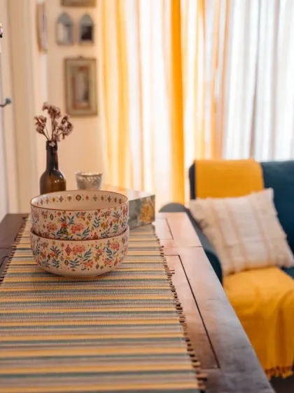 It's all about coordination. The striped table runner echoes the colors of the living room decor, tying the dining and living spaces together in a cohesive, beautifully styled look.
