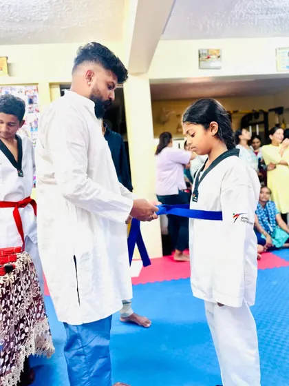 Another student proudly receives her blue belt.