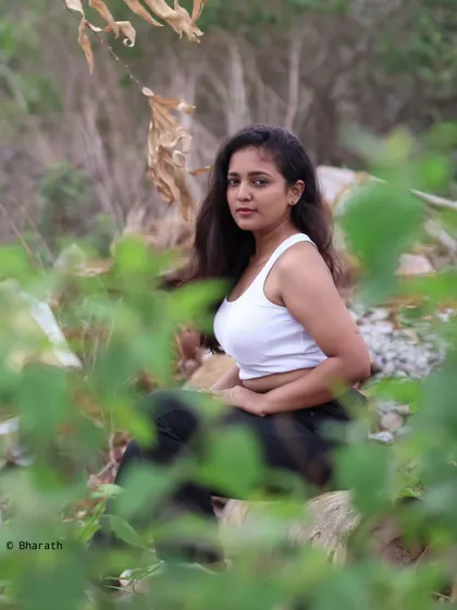 Another perspective using foreground framing, this portrait feels intimate and natural, set against a wild, green backdrop.