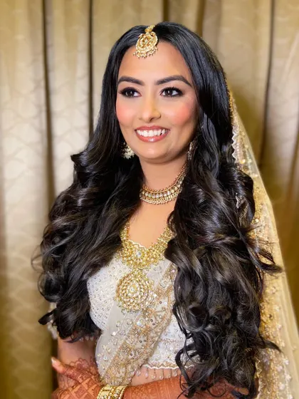 This shot captures the beautiful harmony between Bansi's soft makeup and her voluminous curls, creating a fairytale bridal look.