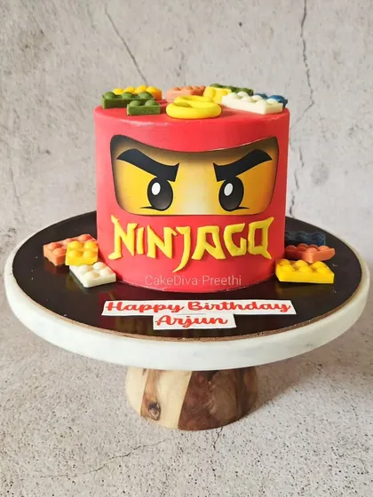 Here's another take on a Lego theme, this time for a Ninjago lover. This cake features the iconic face of the red ninja, Kai, and is topped with edible chocolate Lego bricks.