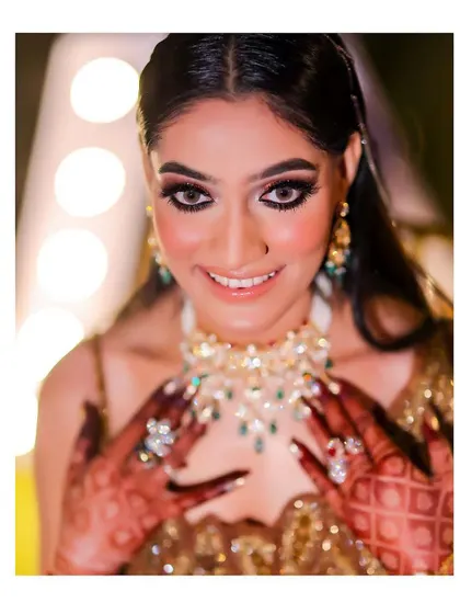 A stunning close-up of the bride, her eyes sparkling. This portrait captures her joy and the intricate details of her jewelry and mehndi.
