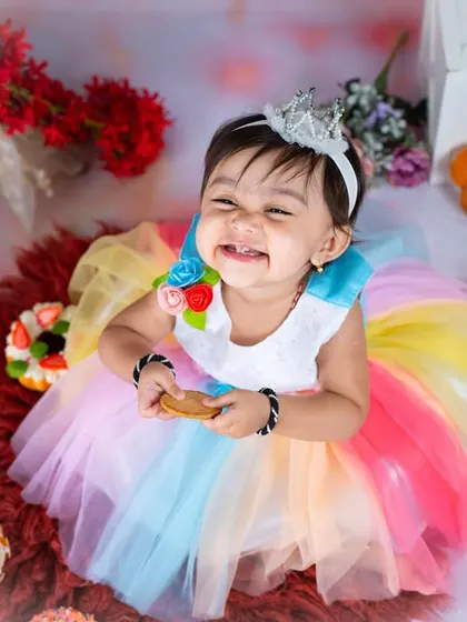 A huge, happy grin from our cookie princess. Her joy is absolutely contagious in this fun and colorful setup.