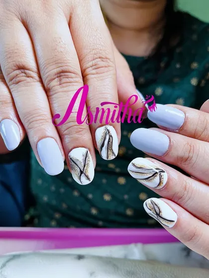 A fresh and artistic nail set combining a matte periwinkle blue with white accent nails. The accent nails feature a delicate, abstract marble design in black and gold.
