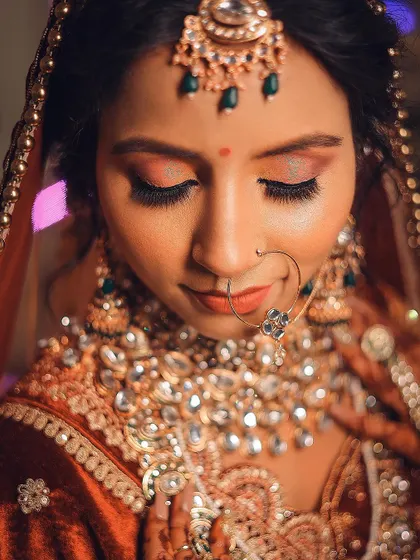A warm-toned close-up that brings out the golden hues in the bride's jewelry and makeup.