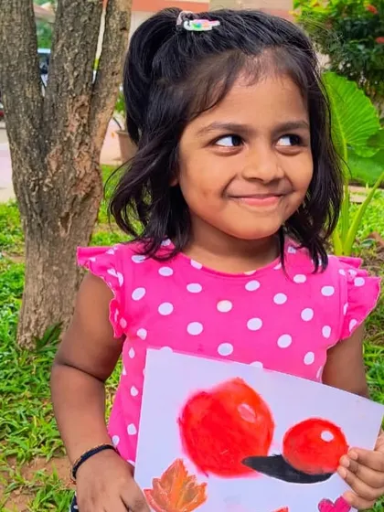 A duplicate image of a young artist proudly holding her colorful still life painting.