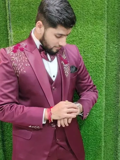 A customer checking the time, but we know he's checking out how good he looks in our maroon embroidered suit.