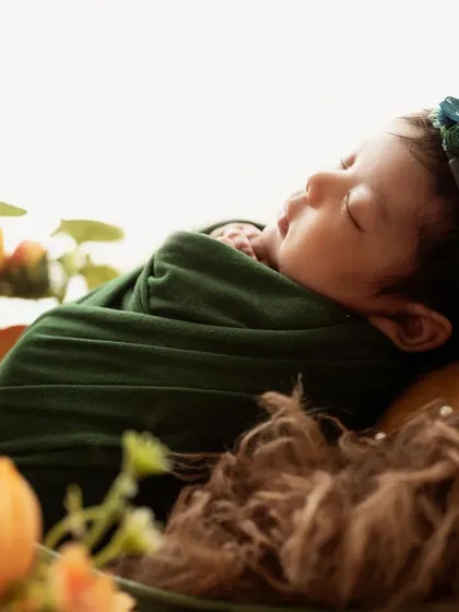 A beautiful profile shot of the sleeping baby, backlit to create a soft, angelic glow.