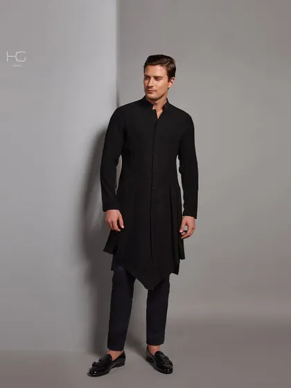 Bold in black. This asymmetrical longline kurta offers a modern, edgy take on traditional menswear, creating a powerful statement with its unique silhouette.