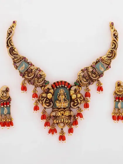 This is a truly regal piece from my collection. A handcrafted bridal necklace set featuring a depiction of Goddess Lakshmi, surrounded by intricate metalwork and vibrant red coral beads. This is the kind of heirloom-quality jewellery that is passed down through generations.