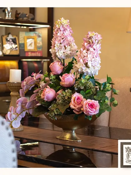 Another view of a classic floral arrangement, showcasing a beautiful mix of pink roses and hyacinths in a golden pedestal bowl. It adds a touch of elegance to a console table.