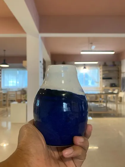 A beautiful vase with a deep blue and white glaze, created by a student. The contrast of colors and the classic shape make this a timeless piece.