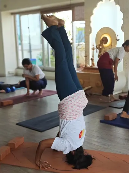 Inversions are a key component of our TTC. A student practices Sirsasana (Headstand), learning to build the core and shoulder strength necessary for safe and stable inversions.