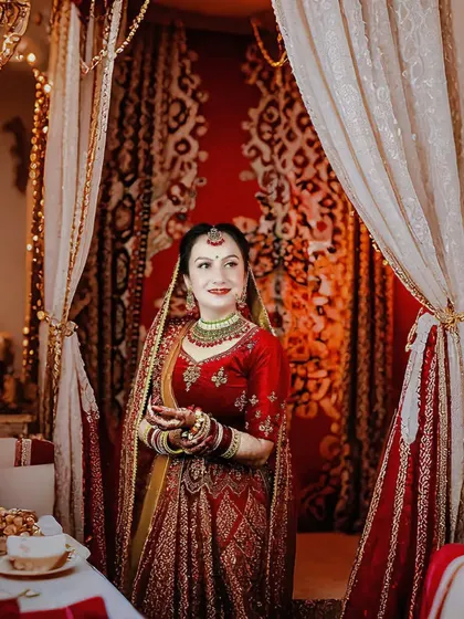A candid shot of the bride in a beautifully decorated room. This photo feels like a scene from a movie, full of warmth and anticipation.