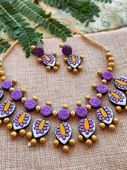 A sleek and lightweight two-layer necklace with leaf-patterned charms in purple and yellow. This is a delicate and feminine design.
