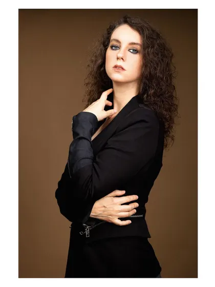 A powerful and elegant portrait of a model in a black blazer. The lighting is dramatic, carving out her features and creating a sophisticated, high-fashion look.