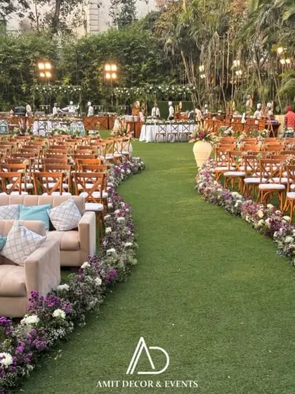 A view of the guest seating area, where a long aisle is flanked by comfortable sofas with pastel blue cushions and rows of chairs, all directed towards the main stage.