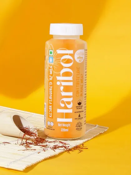 This image for a kesar flavored milk uses a warm, monochromatic yellow theme. The styling with saffron strands clearly highlights the key ingredient and creates a premium, artisanal feel.