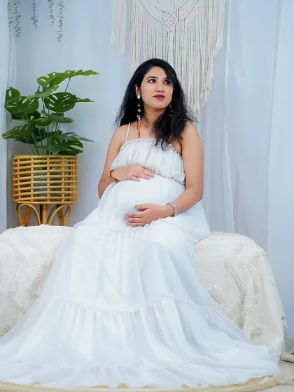 A serene portrait from an indoor maternity shoot. The makeup is subtle and elegant, enhancing her features while maintaining a very natural and comfortable feel.