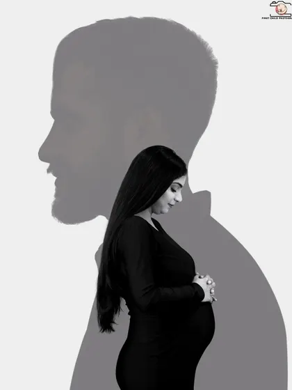 A creative double exposure in black and white. The silhouette of the partner's profile creates a frame for the solo portrait of the mother-to-be, symbolizing his protective presence.
