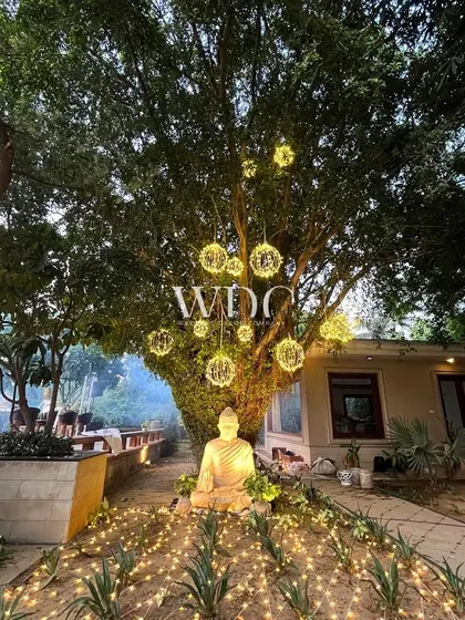 A serene and spiritual corner of the party, with a Buddha statue illuminated by fairy lights, creating a tranquil and beautiful focal point.