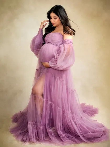 This mumma-to-be looks absolutely radiant in a flowing purple gown from my studio collection. The off-shoulder style and sheer fabric add a touch of romance and drama.