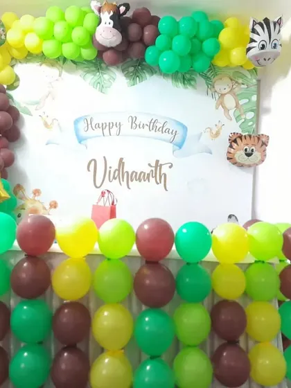 A vibrant and fun jungle theme for Vidhaarth's 2nd birthday. The backdrop is surrounded by a colorful balloon arrangement and animal cutouts.
