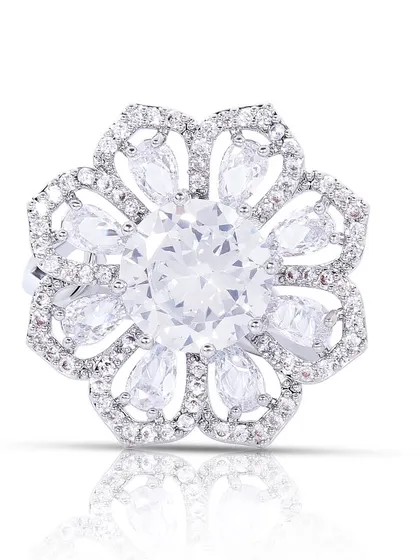 A top-down view of a large, flower-shaped diamond ring on a white background, highlighting the complex arrangement of the stones.