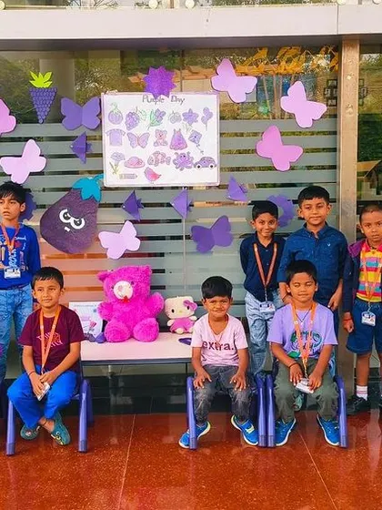 A group of boys poses in front of the Purple Day decorations, enjoying the festive atmosphere.