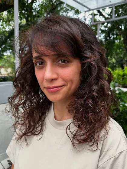 A beautiful portrait of our curly-haired client, showing how the new cut and subtle highlights frame her face perfectly.