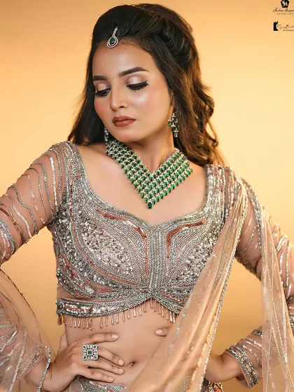 A stunning look with a heavily embellished blouse and a beautiful emerald necklace. The makeup is kept warm and neutral to let the accessories shine.
