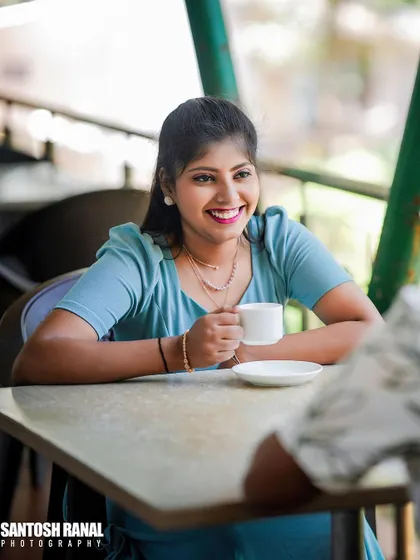 A candid over-the-shoulder shot of the bride smiling during a coffee date scene.
